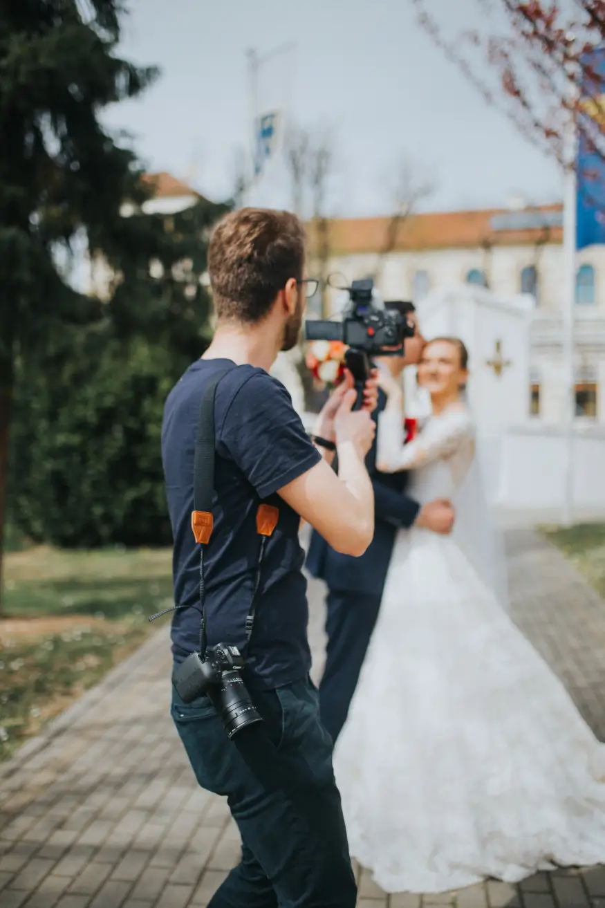 neglubokii_snimok_svadebnogo_fotografa_fotografiruet_zeniha_i_nevestu